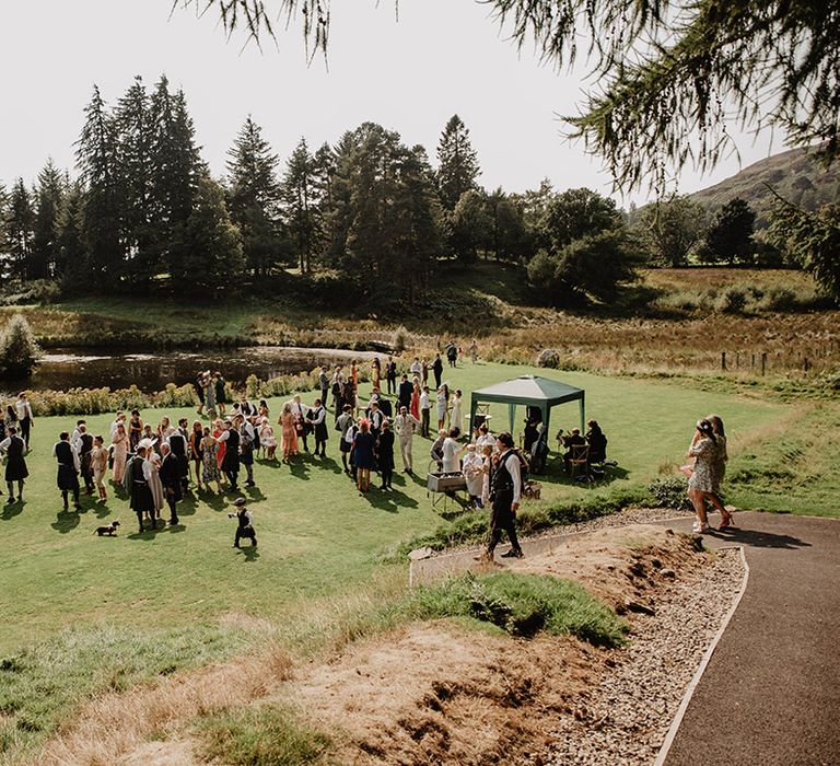 Wedding guests celebrating out on the grounds of Cardney Estate wedding venue in Scotland