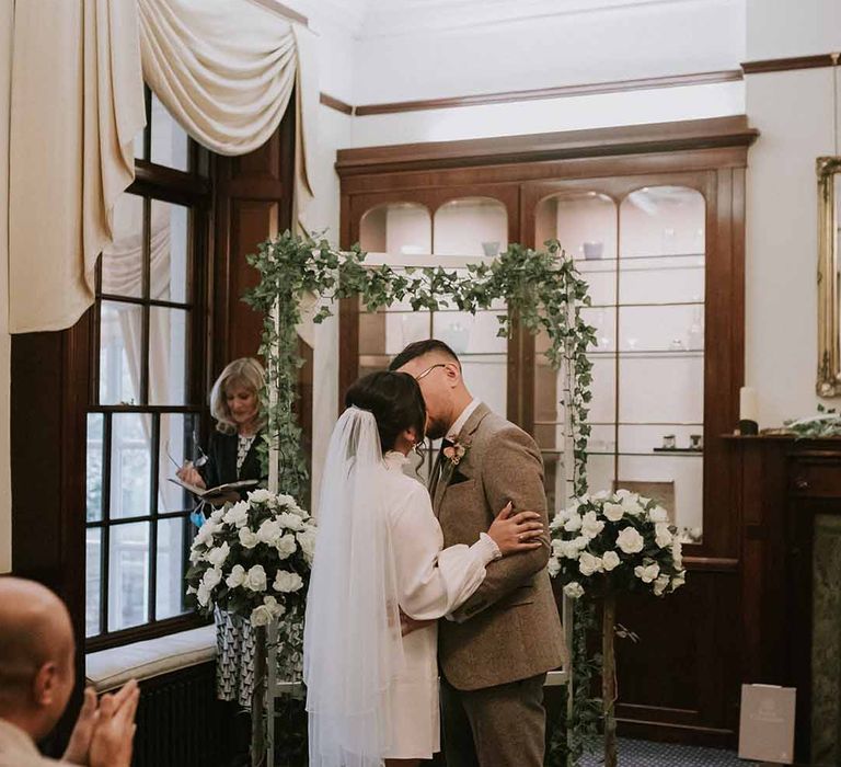 Bride and groom kissing at wedding ceremony at Leatherhead Registry Office, Wotton House