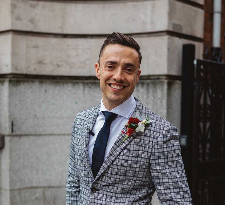 Groom wears grey striped suit complete with floral buttonhole