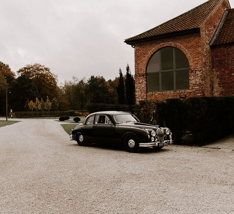 Vintage black wedding car transportation outside the Hazel Gap Barn wedding venue 