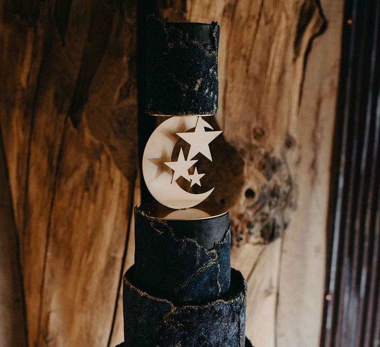 Four tier night sky wedding cake with moon and stars decor cutout with gold icing detail