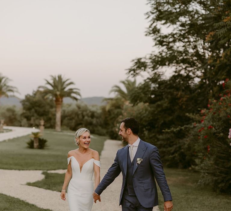 Bride & groom walk through the grounds of Chateau de Robernier on their wedding day after church ceremony 