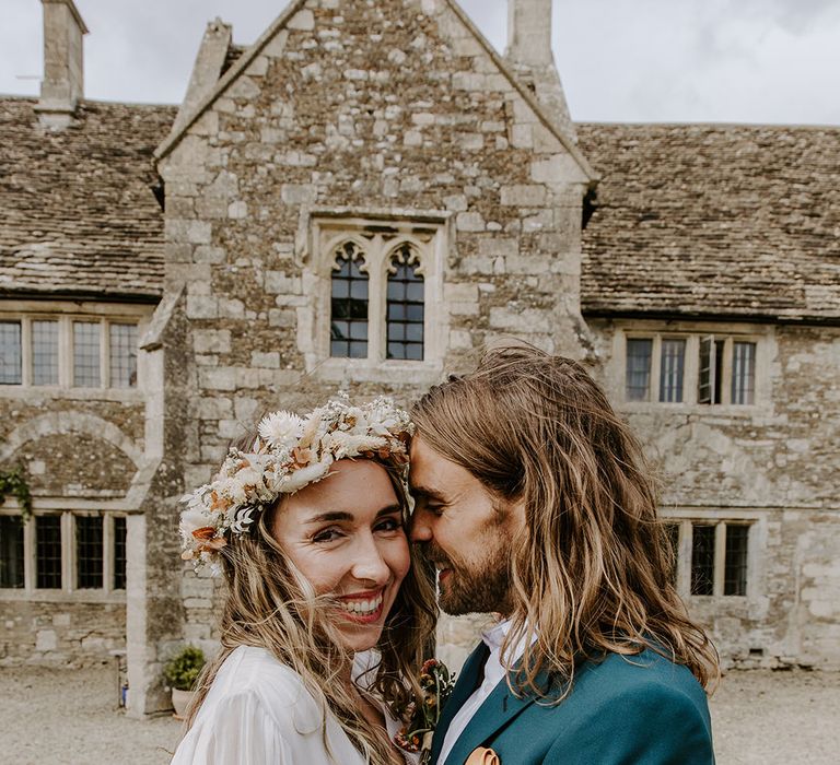 Bride wears floral crown and stands beside her groom 