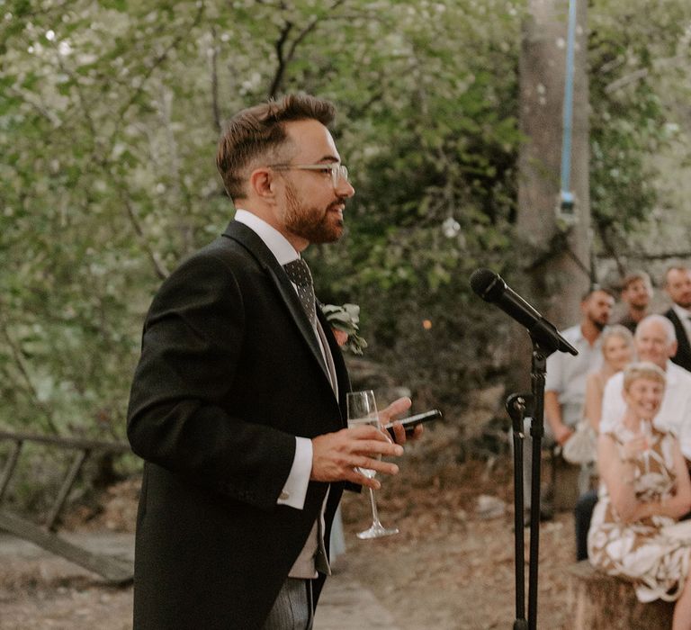 Groom stands up with a microphone as heads out his groom speech 