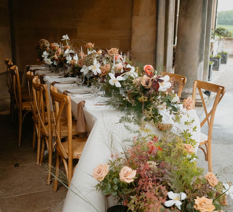 Waterfall effect wedding flowers decorating the tables with white flowers, pink roses and lots of greenery 