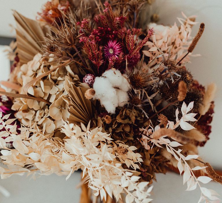 Neutral dried wedding flower bouquet with cotton, dried palm leaves, and hydrangea 