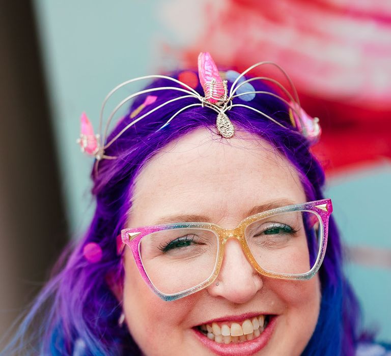 Bride with vibrant purple and blue hair with gemstone bridal crown and multicoloured glasses 