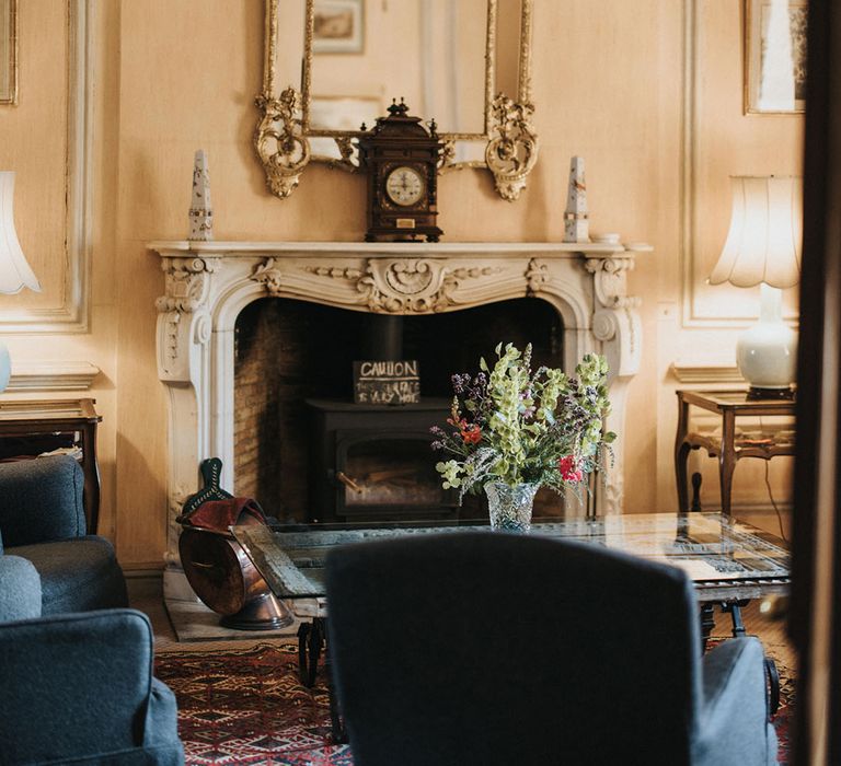 Askham Hall country house and barn wedding venue with fireplace and gold ornate mirror 