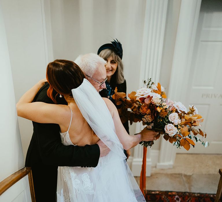 Bride hugs her father on the morning of her wedding day at Reymerston Hall 