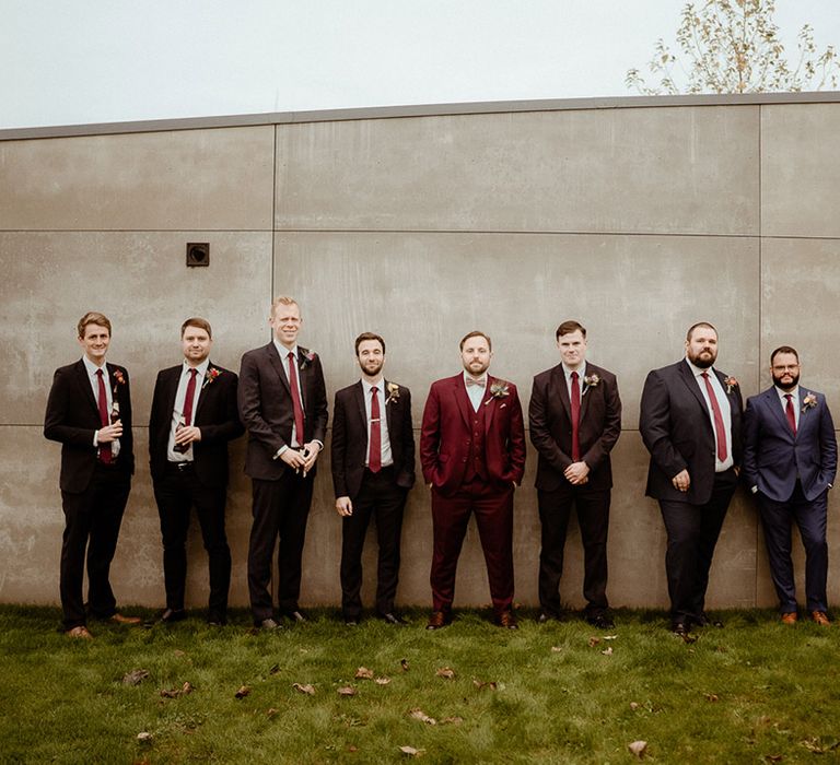 The groom and all the groomsmen in mismatched suits for the boho wedding at Newton Hall 