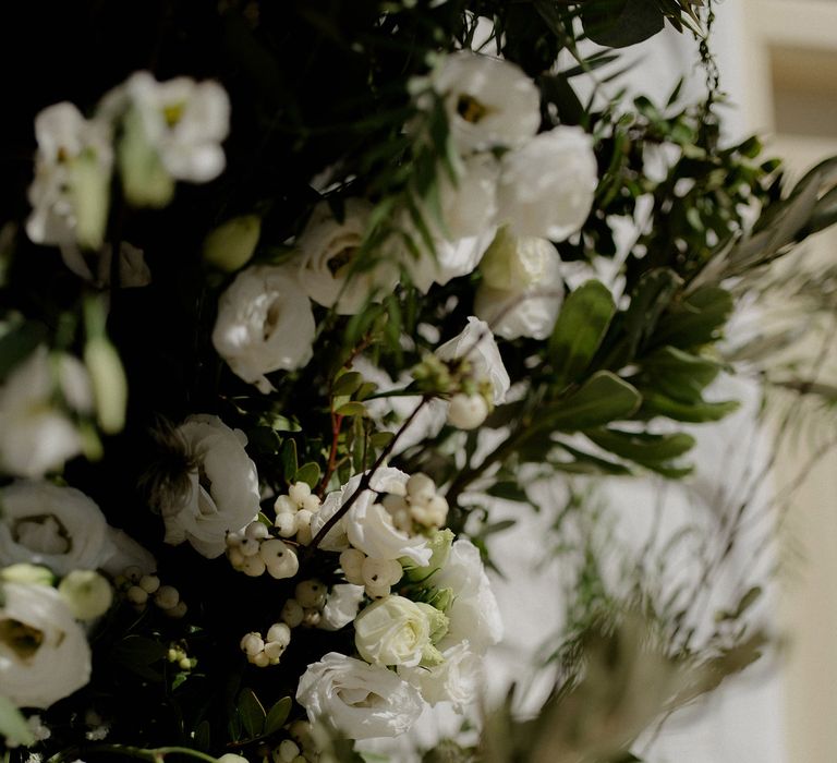 Greek wedding floral decor including white berries, italian ranunculus and eucalyptus