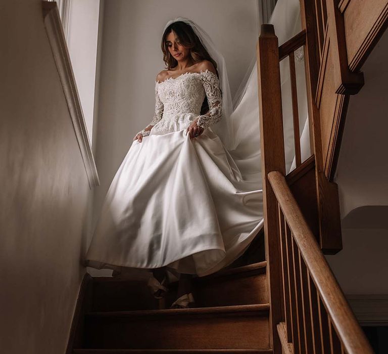 Bride in delicate lace off the shoulder Eva Lendel wedding dress walking down the steps on the way to the wedding 