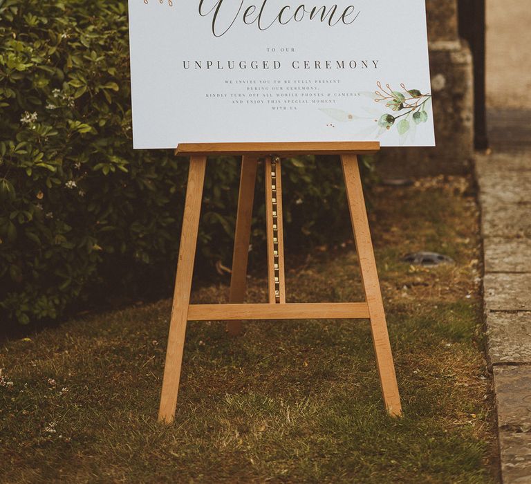 Simple leaf design wedding welcome sign with unplugged ceremony request for guests to keep their phones off for the ceremony 