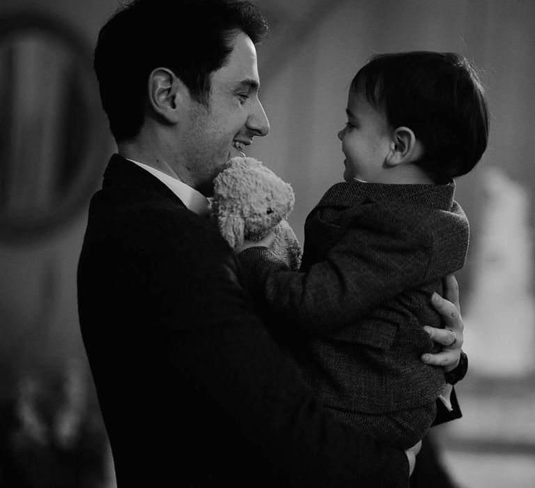 Groom carrying their page boy with little teddy 