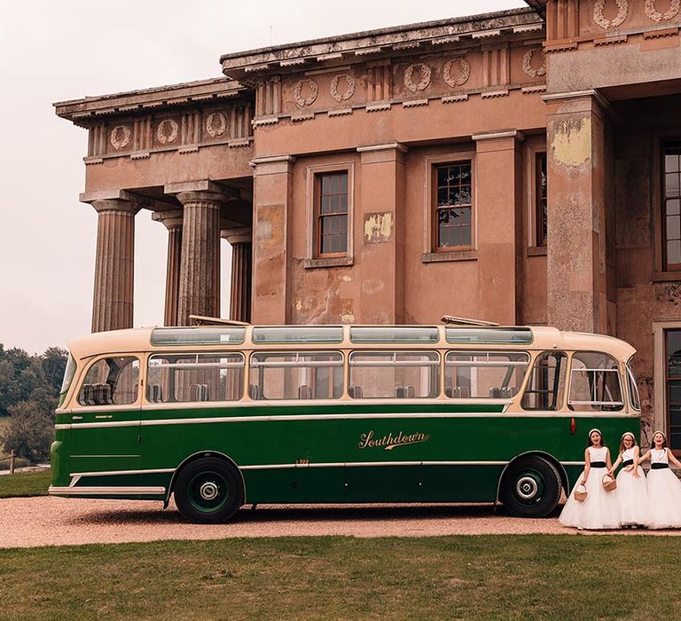 Green and cream vintage style wedding bus with the flower girls wearing white flower girl dresses at mansion wedding in Hampshire