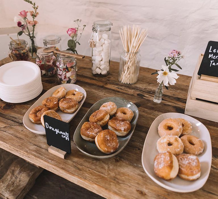 Wedding dessert table with doughnuts, cupcakes, brownies and more goodness