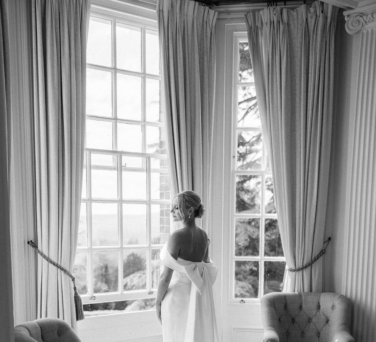 Bride in off the shoulder wedding dress with wedding bow accessory 