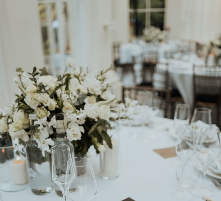 elegant place setting with white flower and green foliage centrepiece 