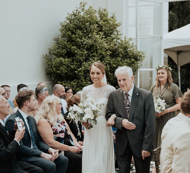 grandfather of the bride walking his granddaughter down the aisle at Gunnersbury Park wedding ceremony 