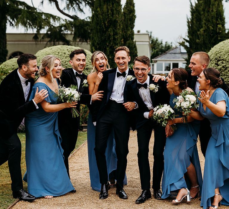 I Do Crew in dusky blue groomsmaid dresses with two grooms at same sex wedding 