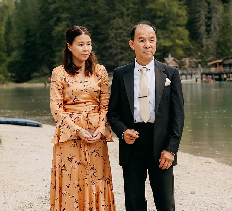 The family members watch the intimate outdoor wedding ceremony 