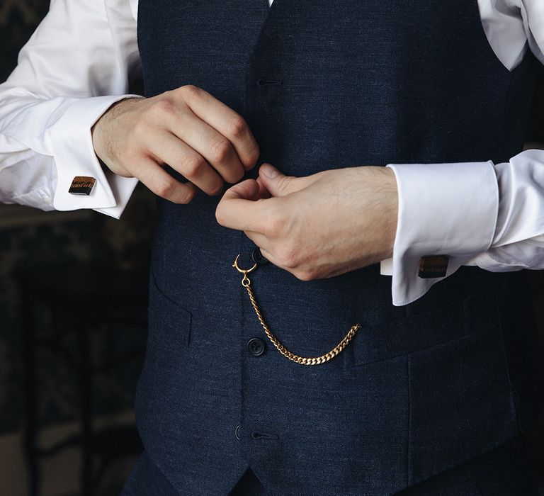 Groom wearing navy suit and gold pocket watch 