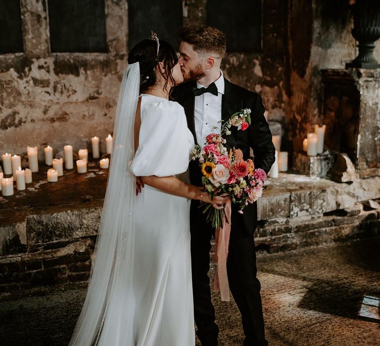 Bride in puff sleeve wedding dress with groom in black tuxedo at city wedding 