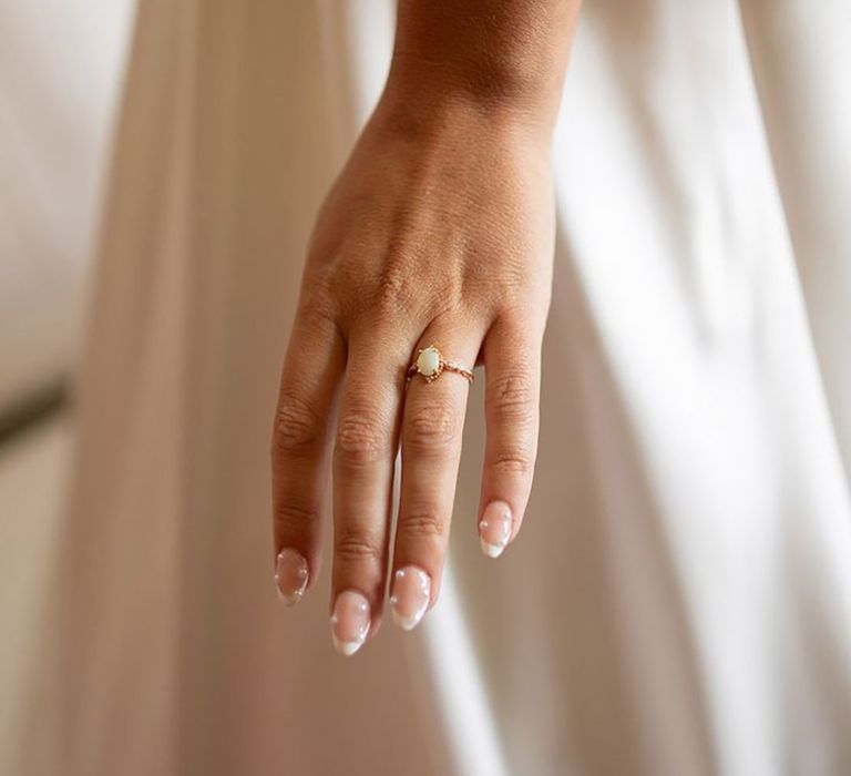 Bride with classic French tip wedding nails embellished with pearls 