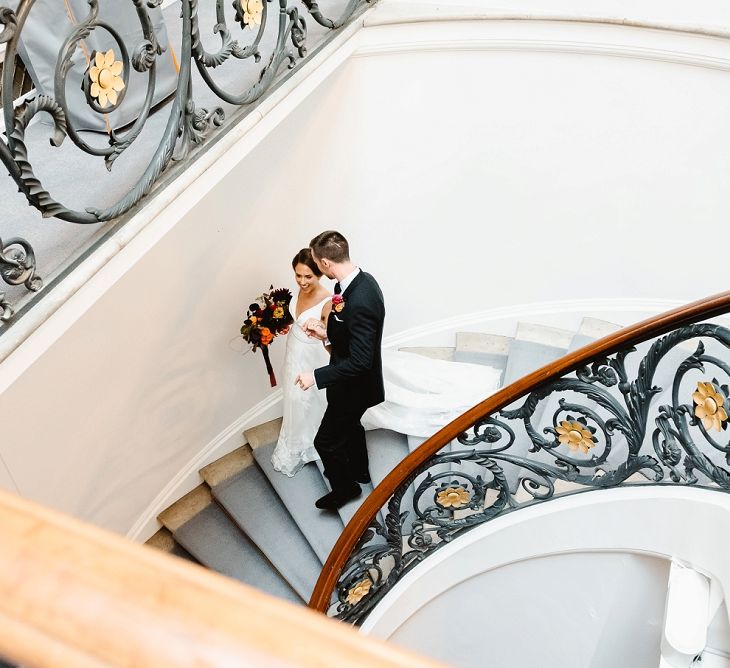 Bride and groom walking down the grand staircase at Carlton House Terrace