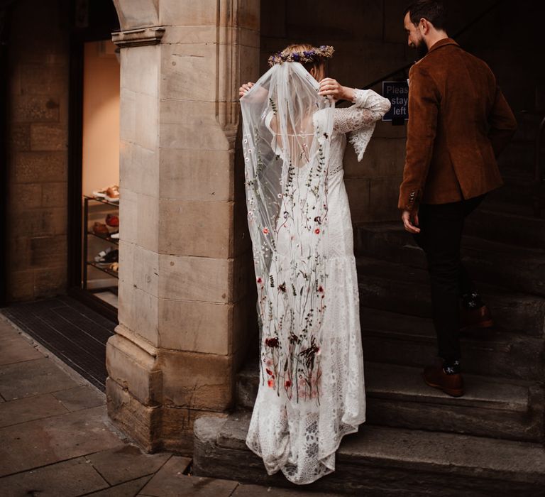 Bride fanning out her embroidered wedding veil 