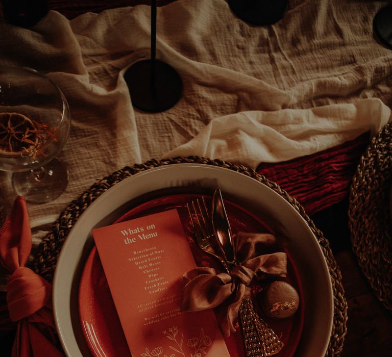 Place setting with menu card and cold cutlery tied with ribbon