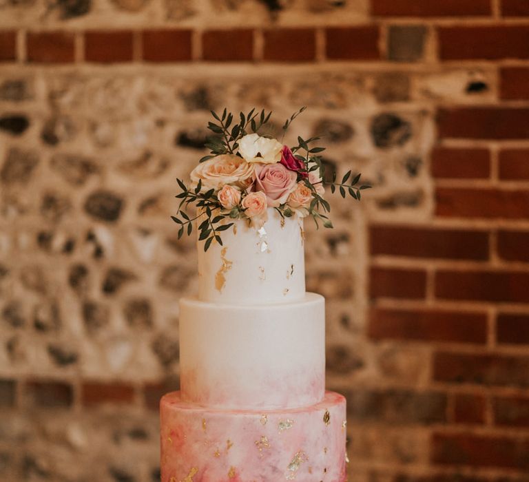 Pink ombre wedding cake with flower topper 