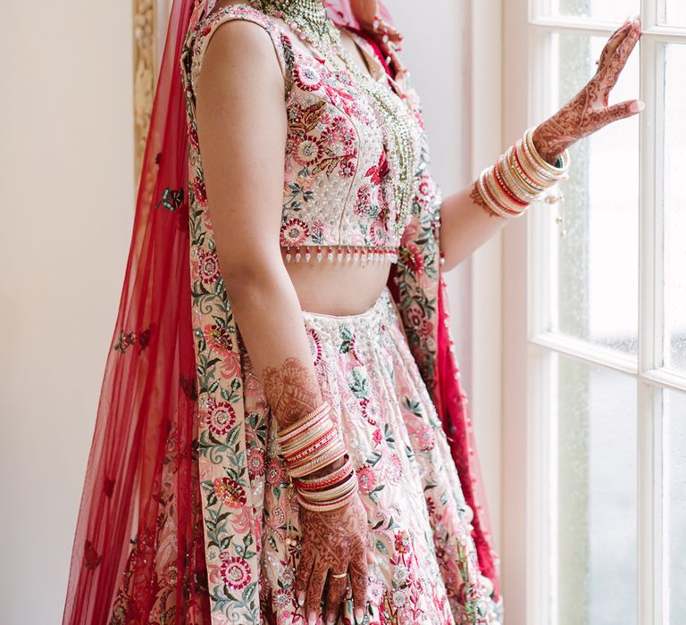 Indian bride in pink wedding dress with red veil and Mangala Sutra necklace