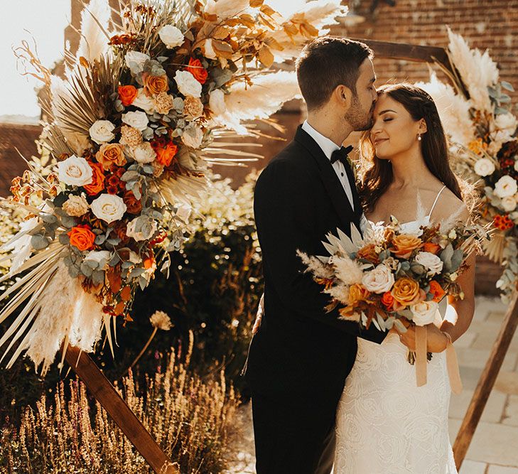 Bride and groom kiss for wedding portrait