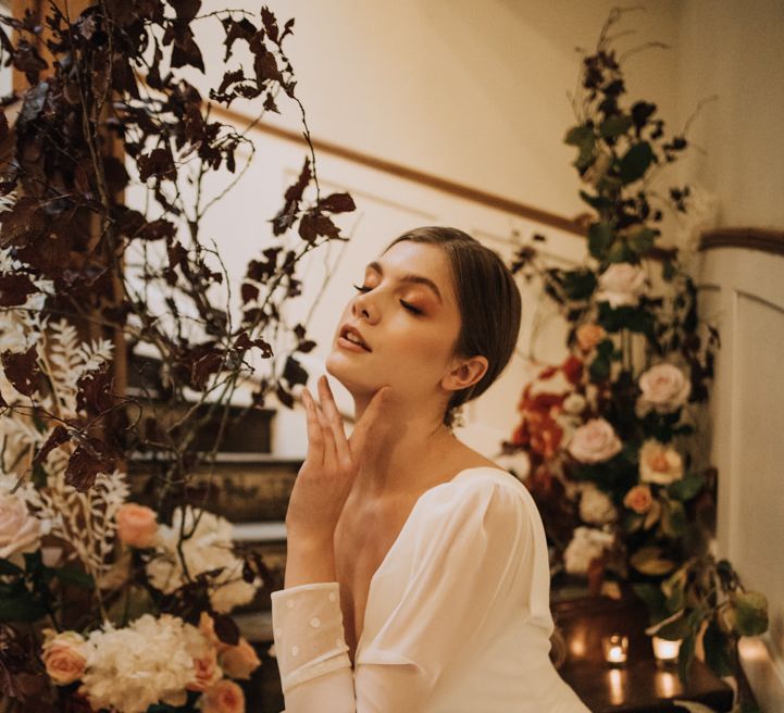 Bride surrounded by autumn flowers and candles