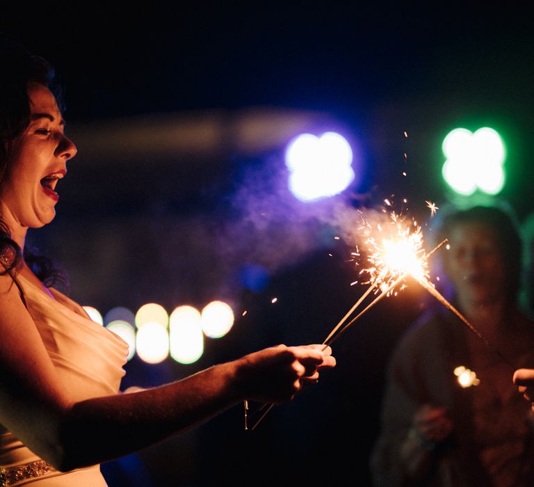 Bride with sparkler at wedding reception 