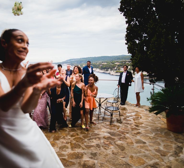 The bride laughing as her bouquet lands into the crowd