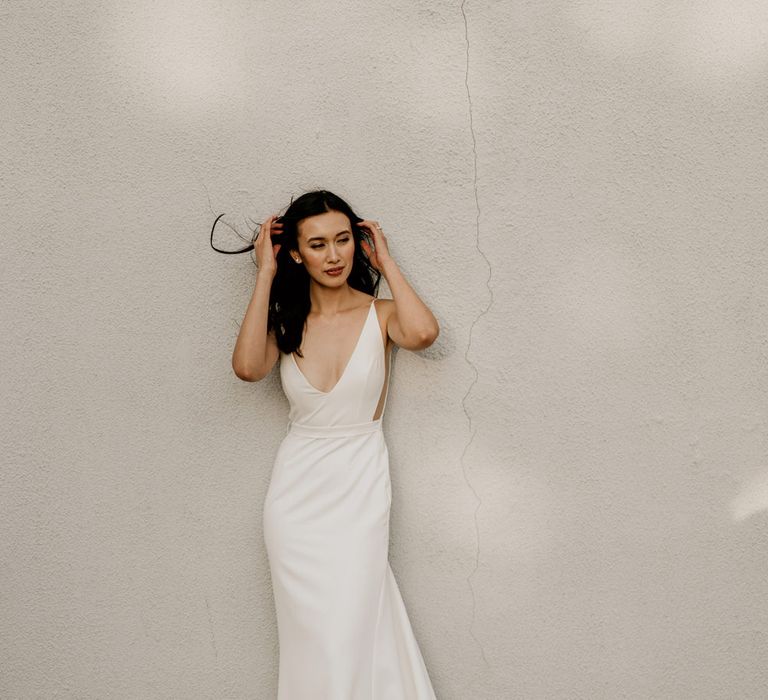 Beautiful bride in a fitted Sarah Seven wedding dress with puddle train and sheer side panels 