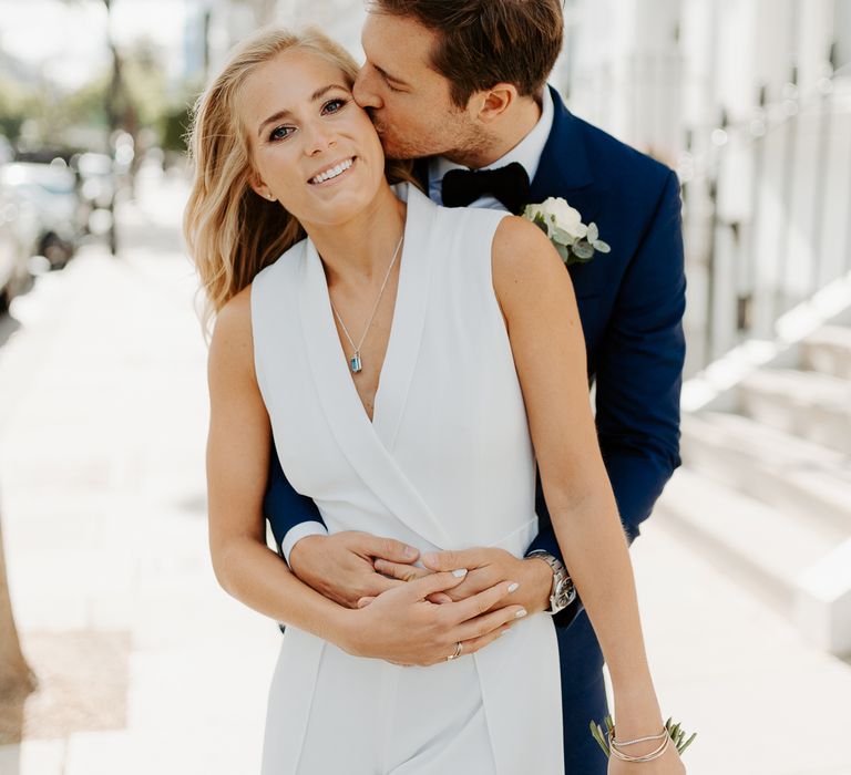 Groom embraces bride during post-wedding photoshoot