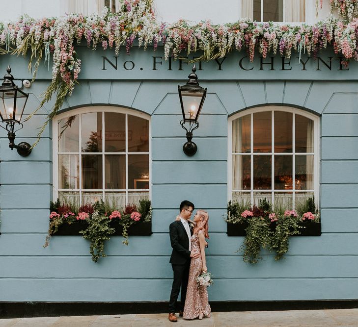 Bride and groom portrait outside a duck eg blue pub with floral hanging baskets 