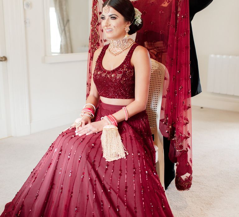 Bride has red veil placed in hair