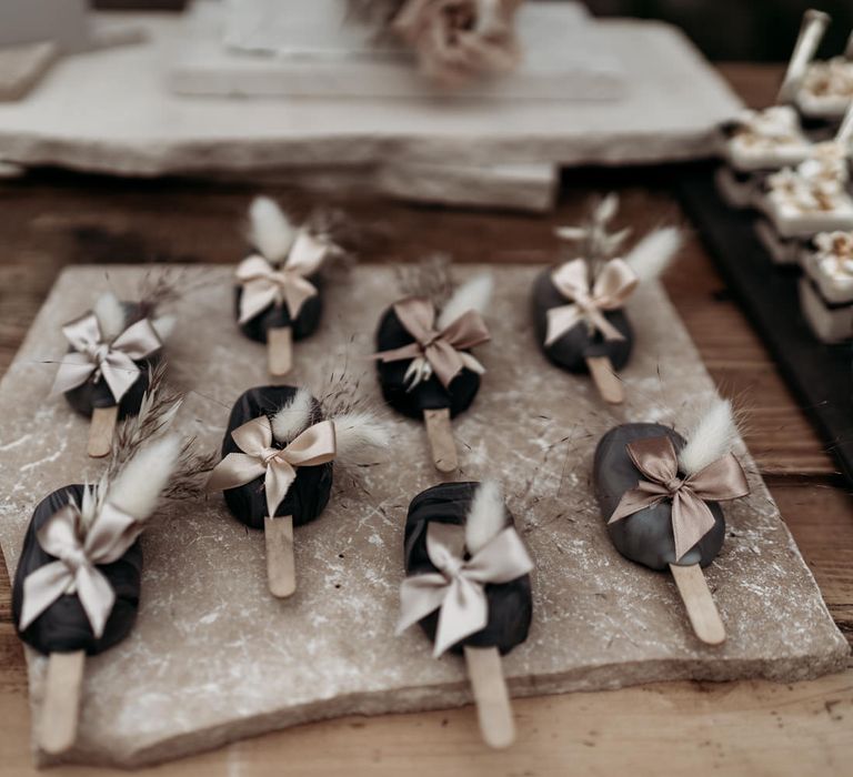 Popsicle wedding cakes with ribbon and dried grass decor 