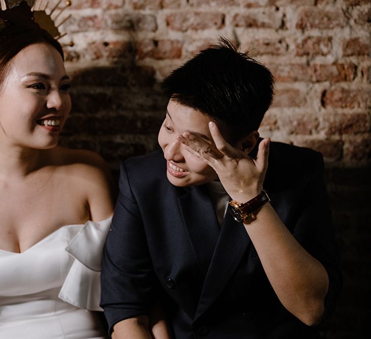 Portraits of two brides in a strapless wedding dress and crown and navy double breasted jacket 