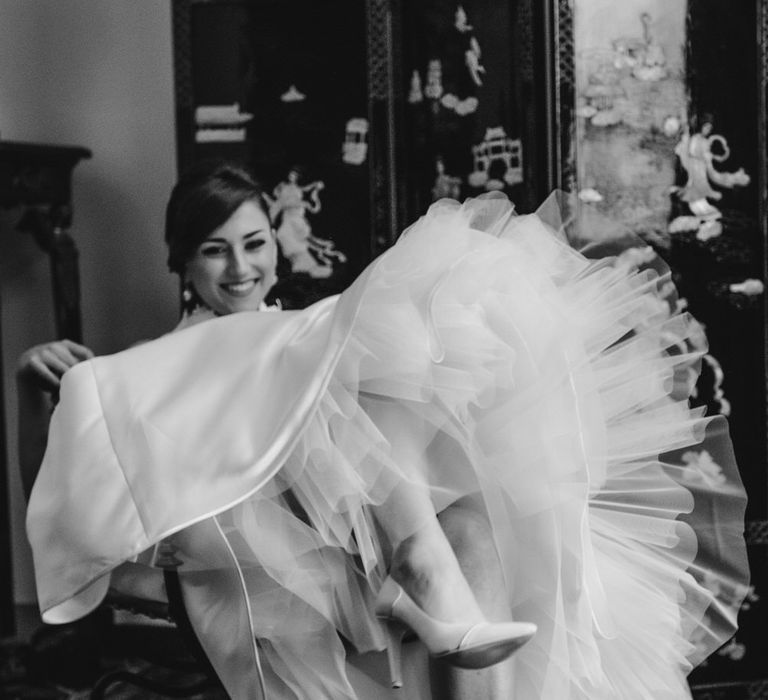 Bride showing off the full netted underskirt of her vintage style wedding dress