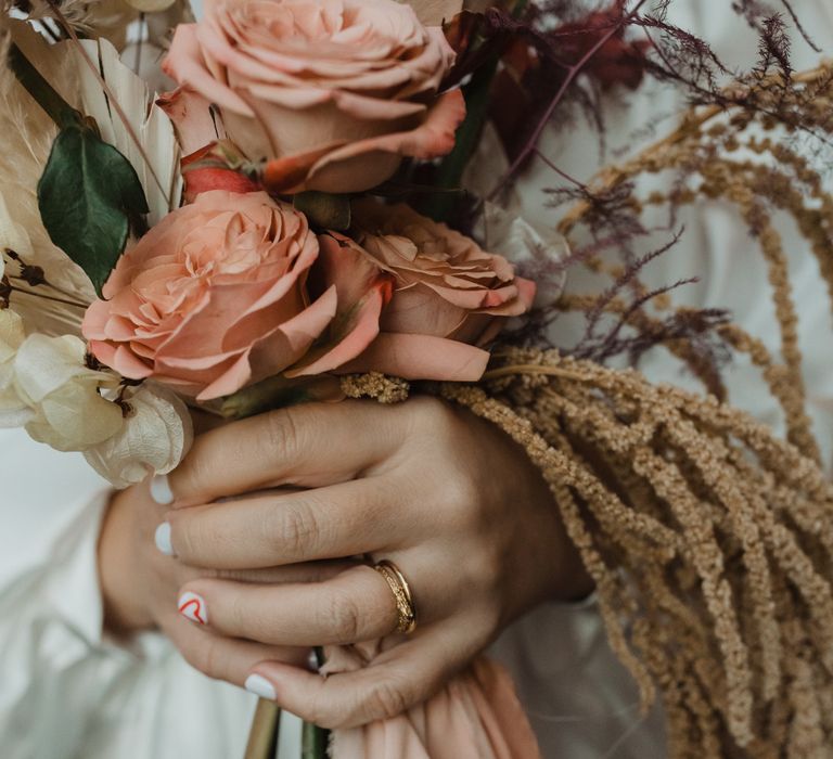 Bride holds floral bouquet with dried flowers and pampas grass