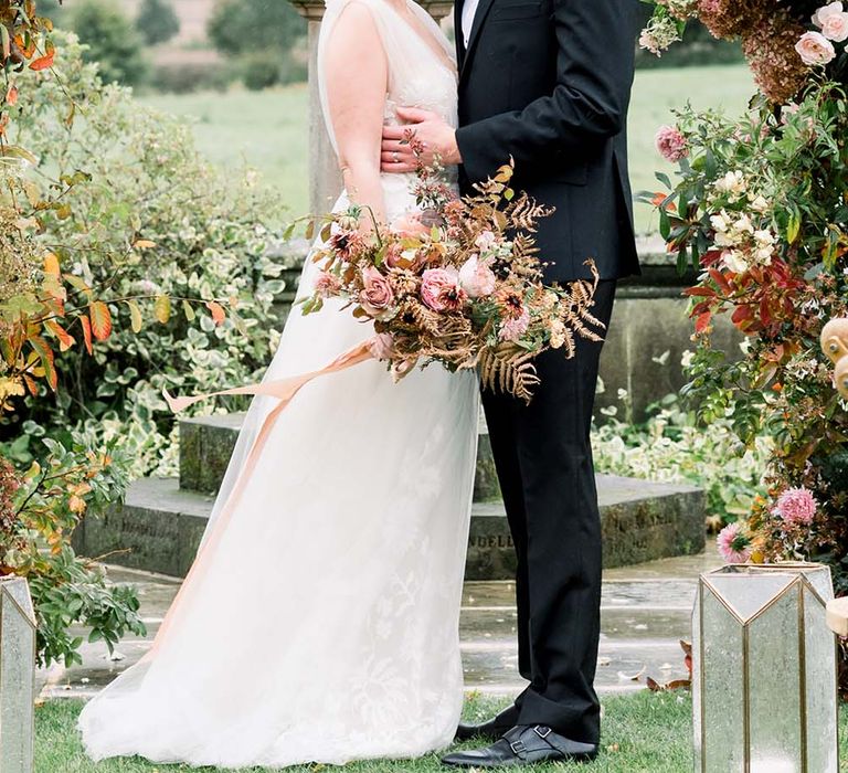 Outdoor black tie wedding at Dorfold hall with grooming Tuxedo and bride in a wrap 