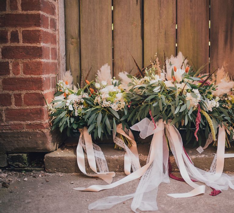 Floral bouquets lined up tied with pink ribbon