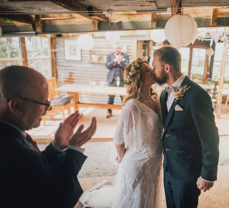 Bride & groom kiss during wedding ceremony