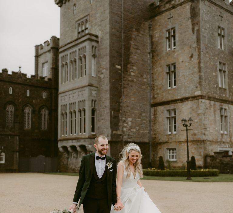 Bride & groom stroll outdoors on their wedding day outside of the Markree Castle