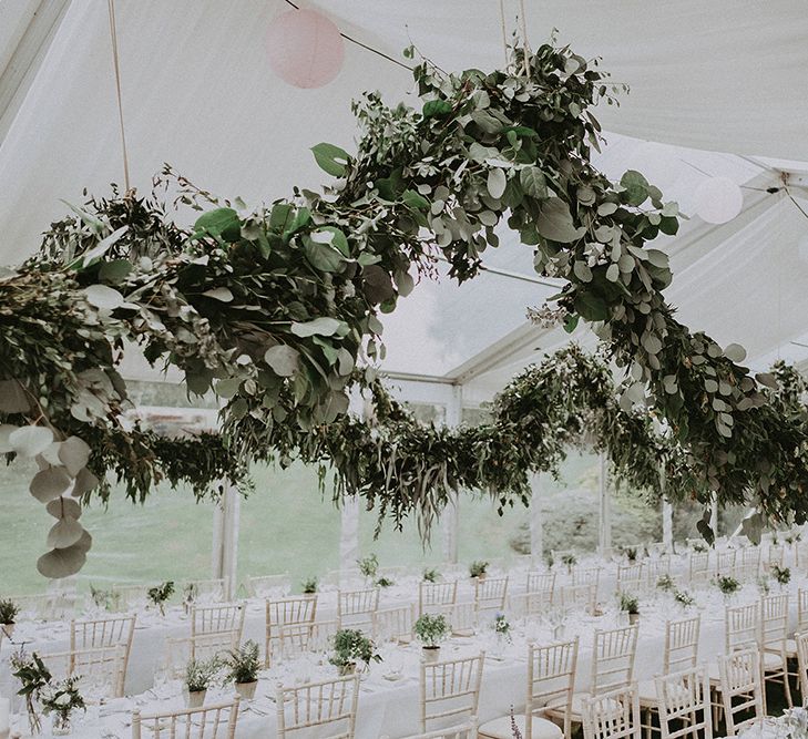 Outdoor classic English wedding marquee, complete with floral installations throughout